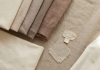 Folded pre-loved garments showing different conditions, flat lay