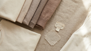 Folded pre-loved garments showing different conditions, flat lay