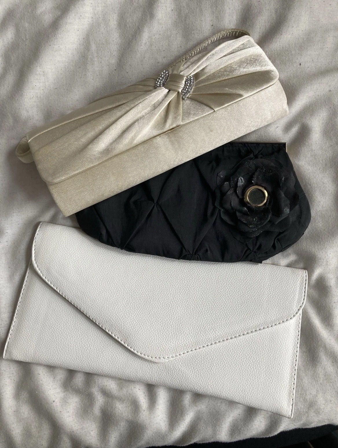 Three party clutch bags: beige, black, and white